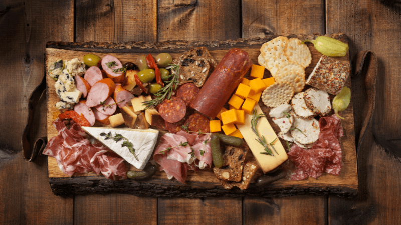 charcuterie board with assorted meat, cheese & garineshes