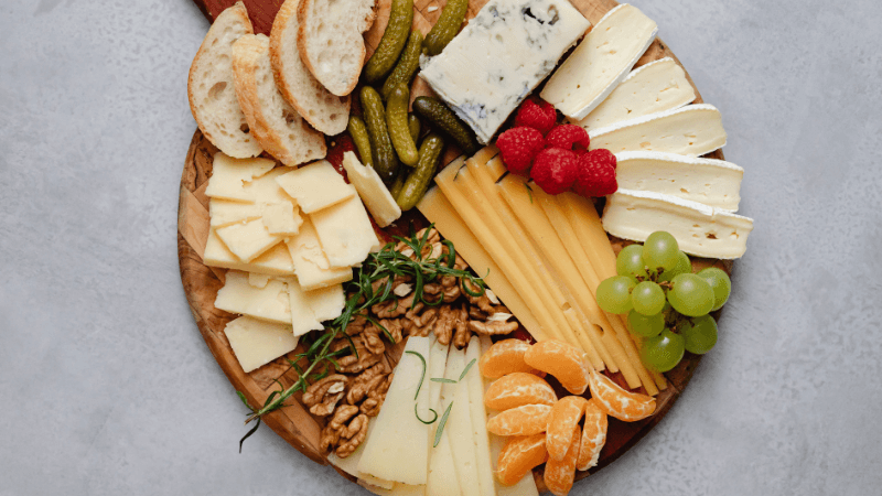 cheese charcuterie board with assorted cheeses & berries