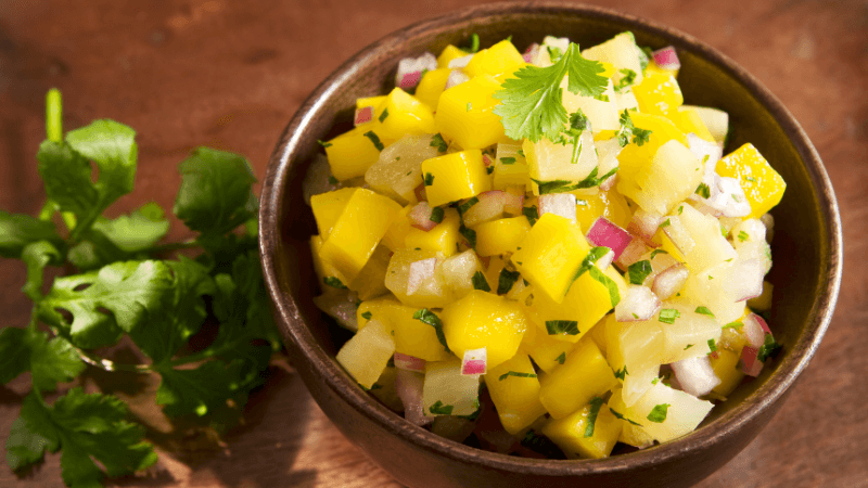 pineapple fruit salsa served in a brown bowl on a wooden table