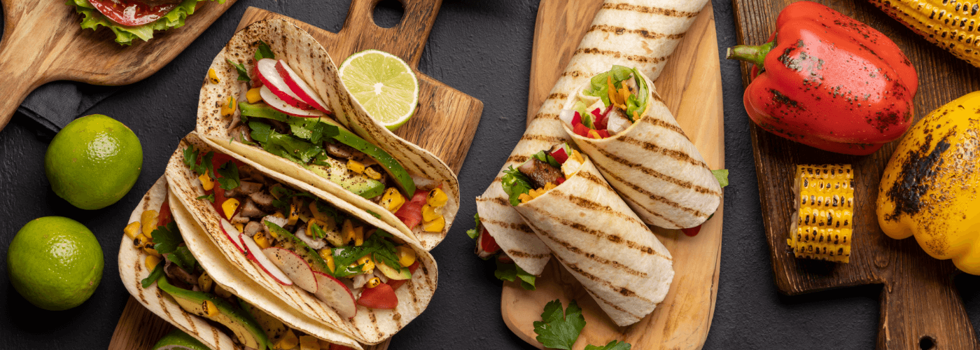 delicious mexican meal such as tacos, burritos, roasted corn & pepper served on wooden boards