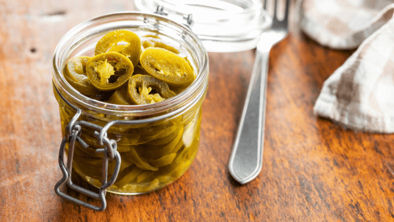 green jalapenos pickle in a glass jar