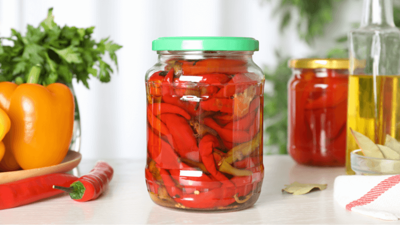 glass jar of pickled pepper on a white table
