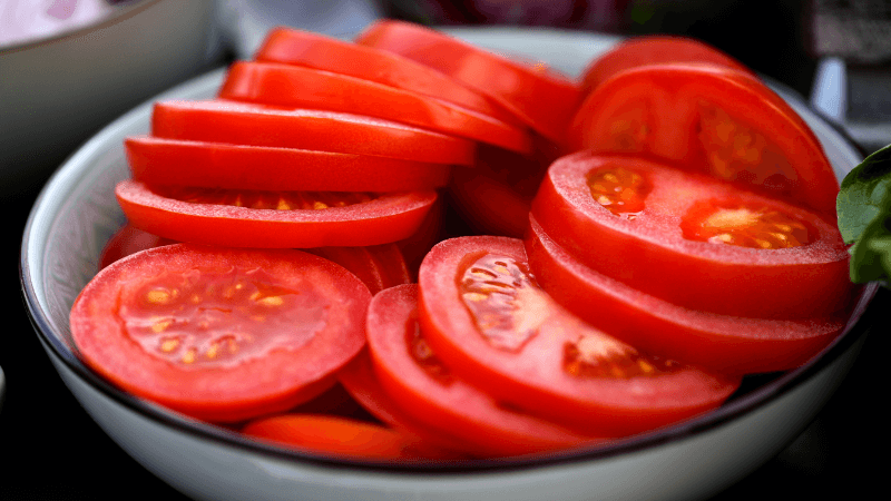 a white bowl containing sliced tomatoes