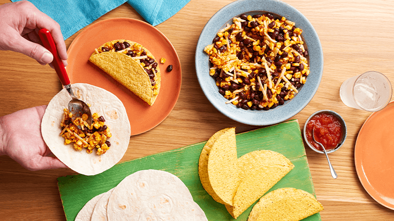 charred corn bean tacos served with fillings in a bowl