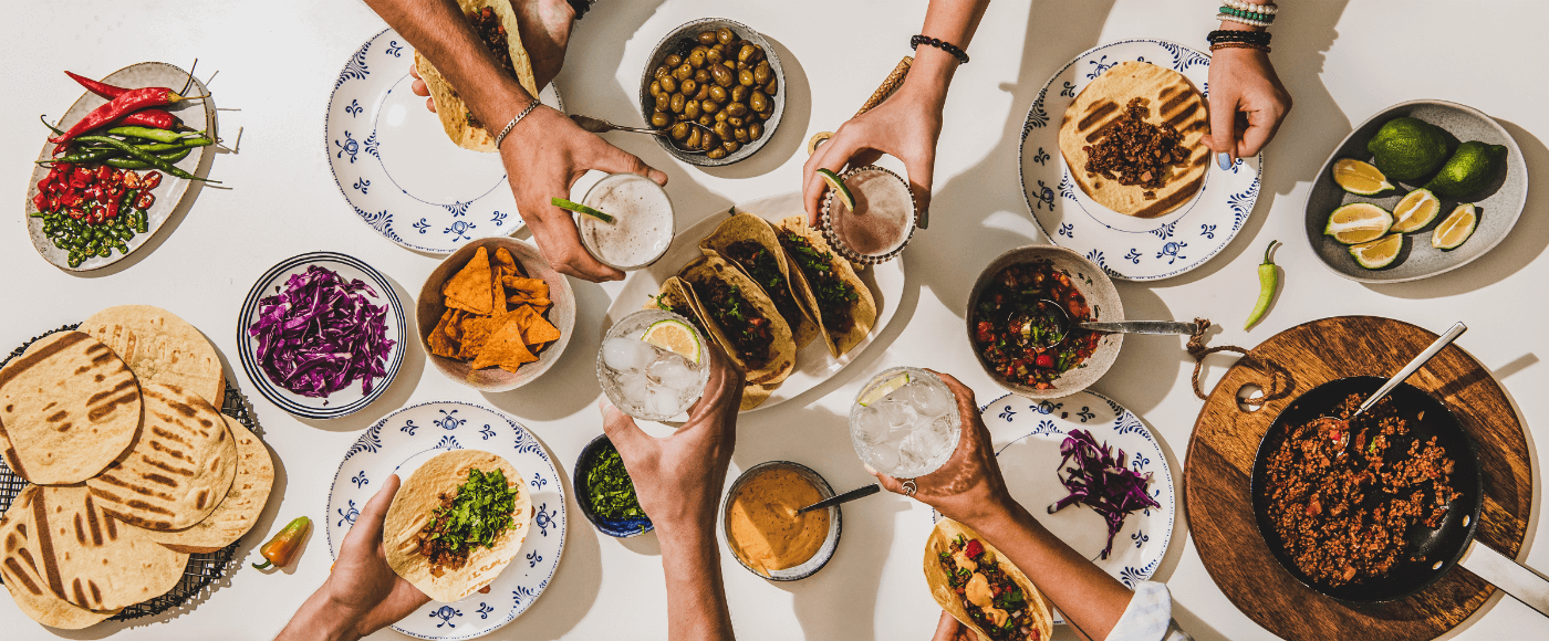 group of people celebrating & enjoying party food on table