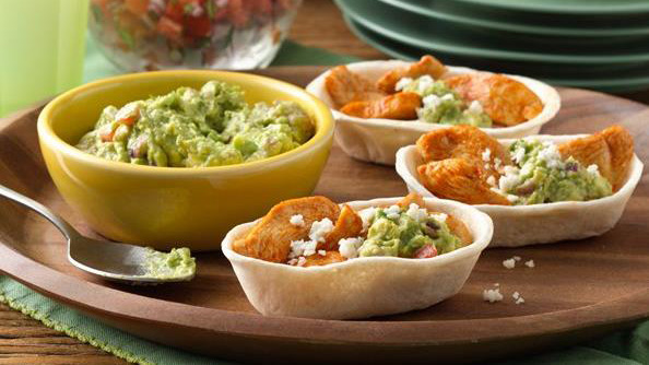 Mini Chicken and Guacamole tacos served on a brown plate