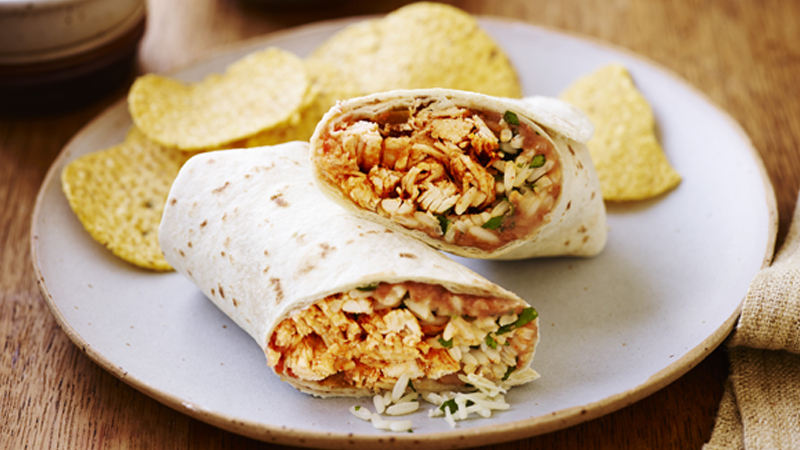 el grande burrito burritos served on a white plate along with the chips