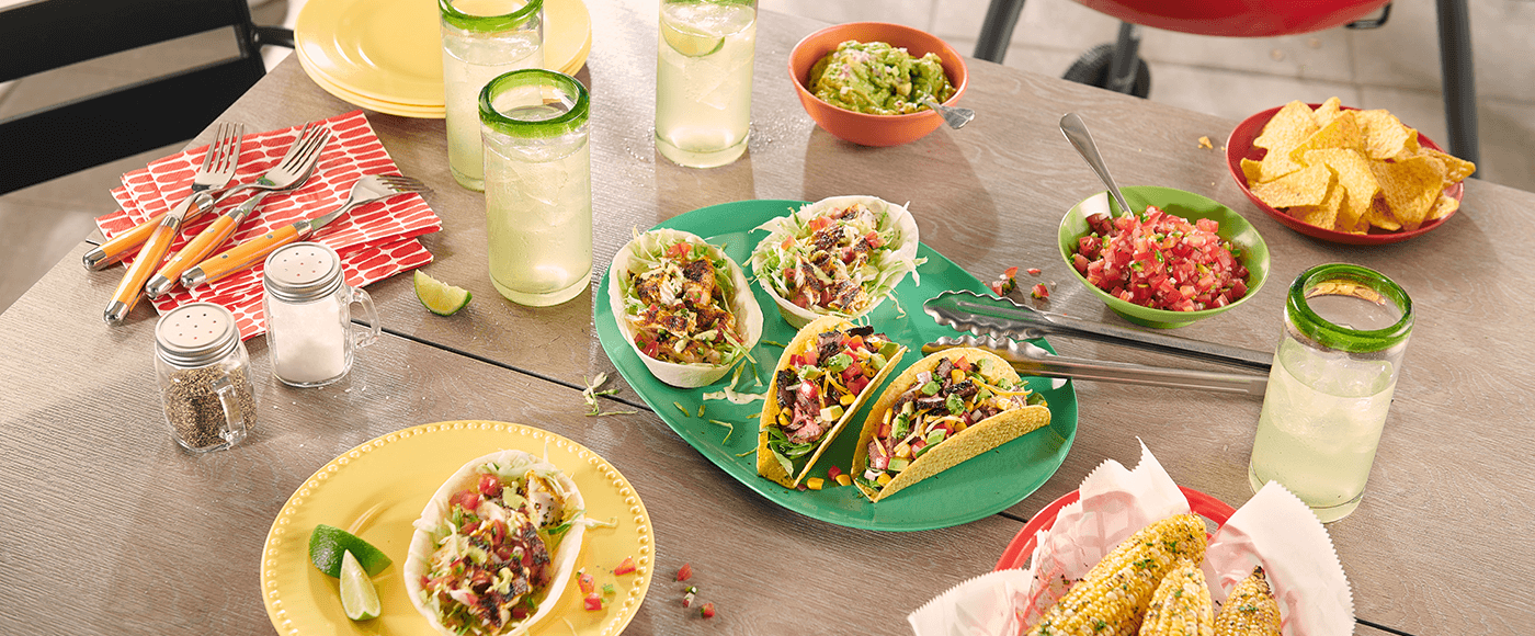 grilled sreak tacos with corn salsa and grilled mahi mahi tacos served on wooden table