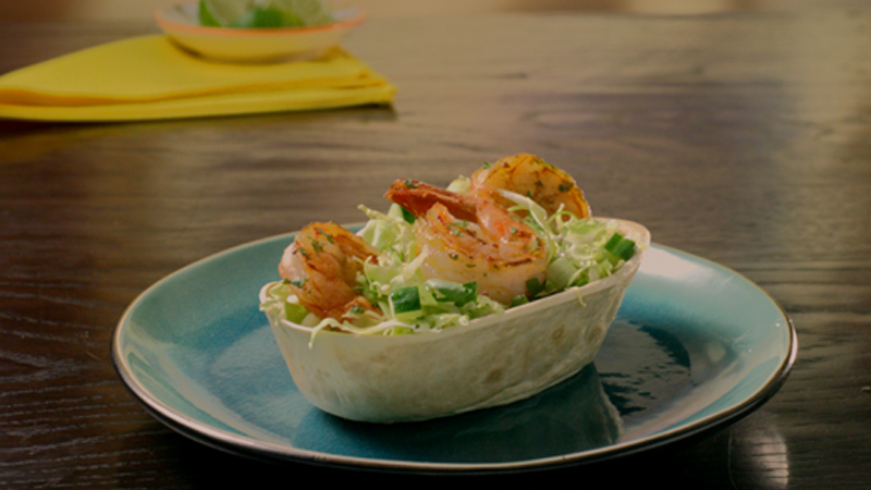 prawns with slaw tacos served in light blue plate placed on a wooden table